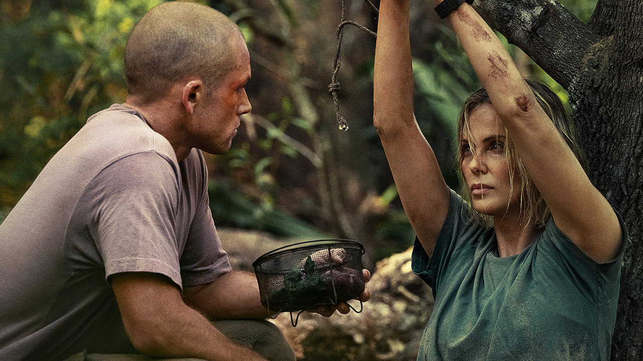Charlize Theron's character and the man hunting her through the forest are standing face-to-face.