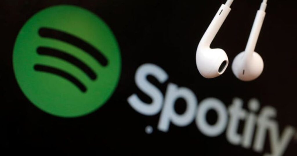 The white Spotify logo on a green background alongside a pair of white wired earphones on a black background.