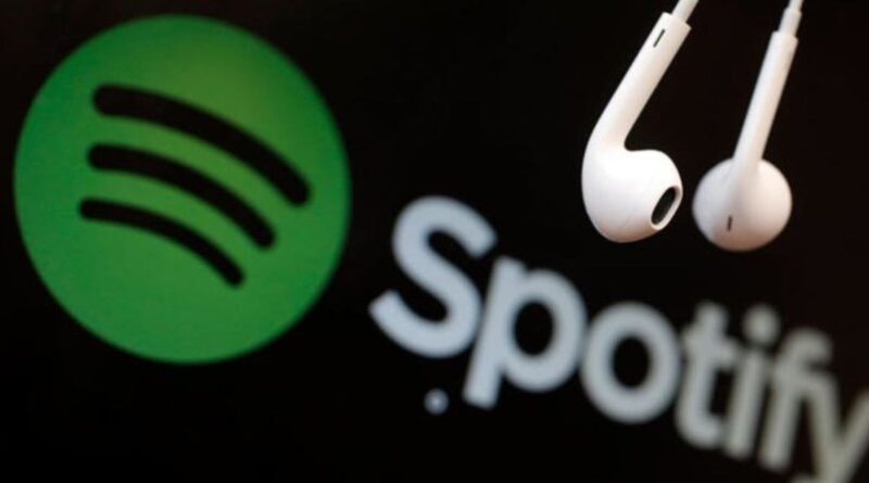 The white Spotify logo on a green background alongside a pair of white wired earphones on a black background.