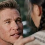 A close-up shot of Val Kilmer looking intently with an emotional expression, with another character's back in the foreground.
