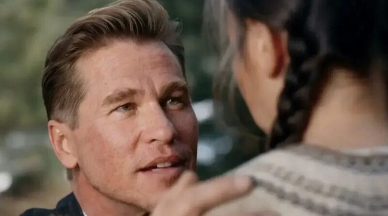 A close-up shot of Val Kilmer looking intently with an emotional expression, with another character's back in the foreground.