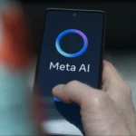 A close-up of a person holding a smartphone displaying the Meta AI interface, featuring a glowing circular logo and the text "Meta AI" on the dark screen.
